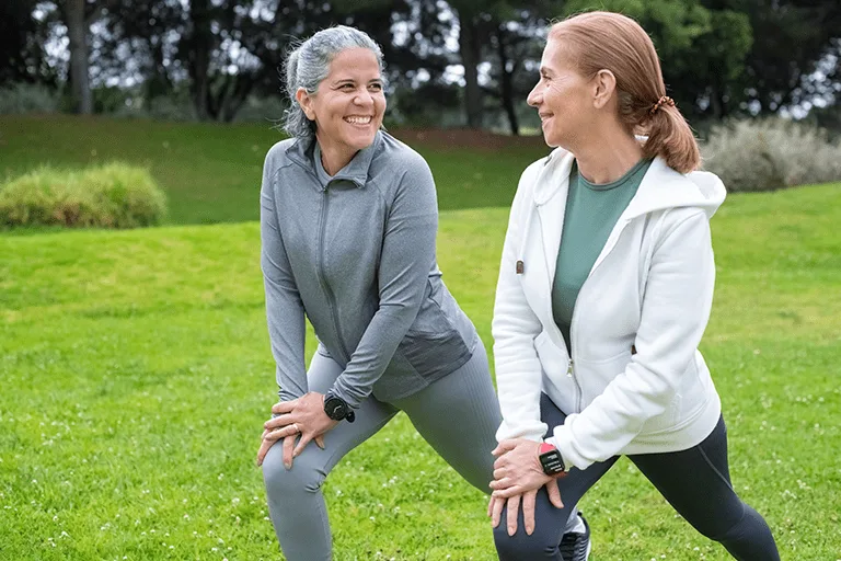 two women stretching in grass field