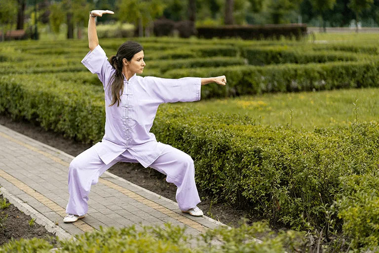 woman doing tai chi in park